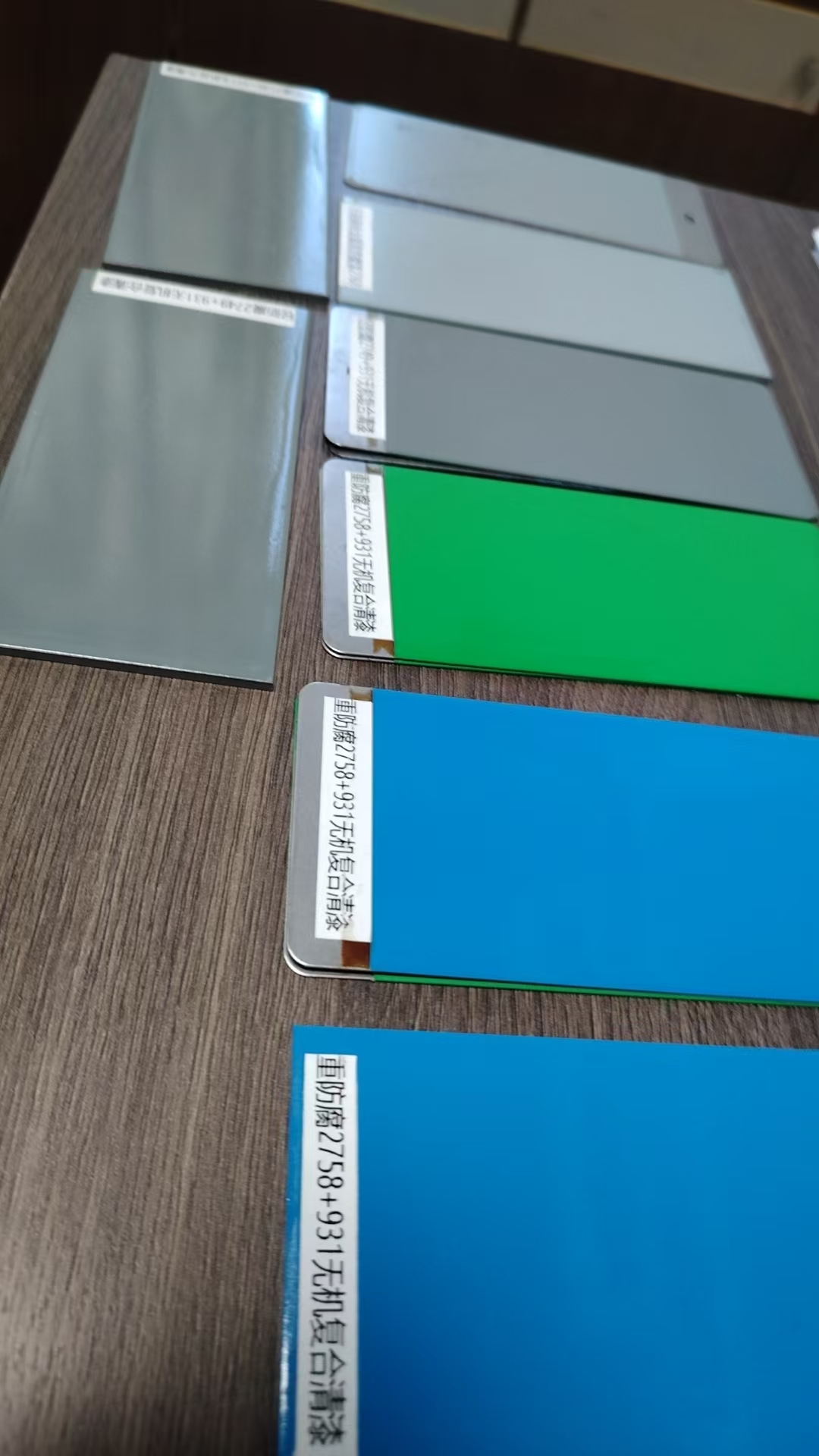 Coated steel test panels in grey, green and blue showing finish consistency